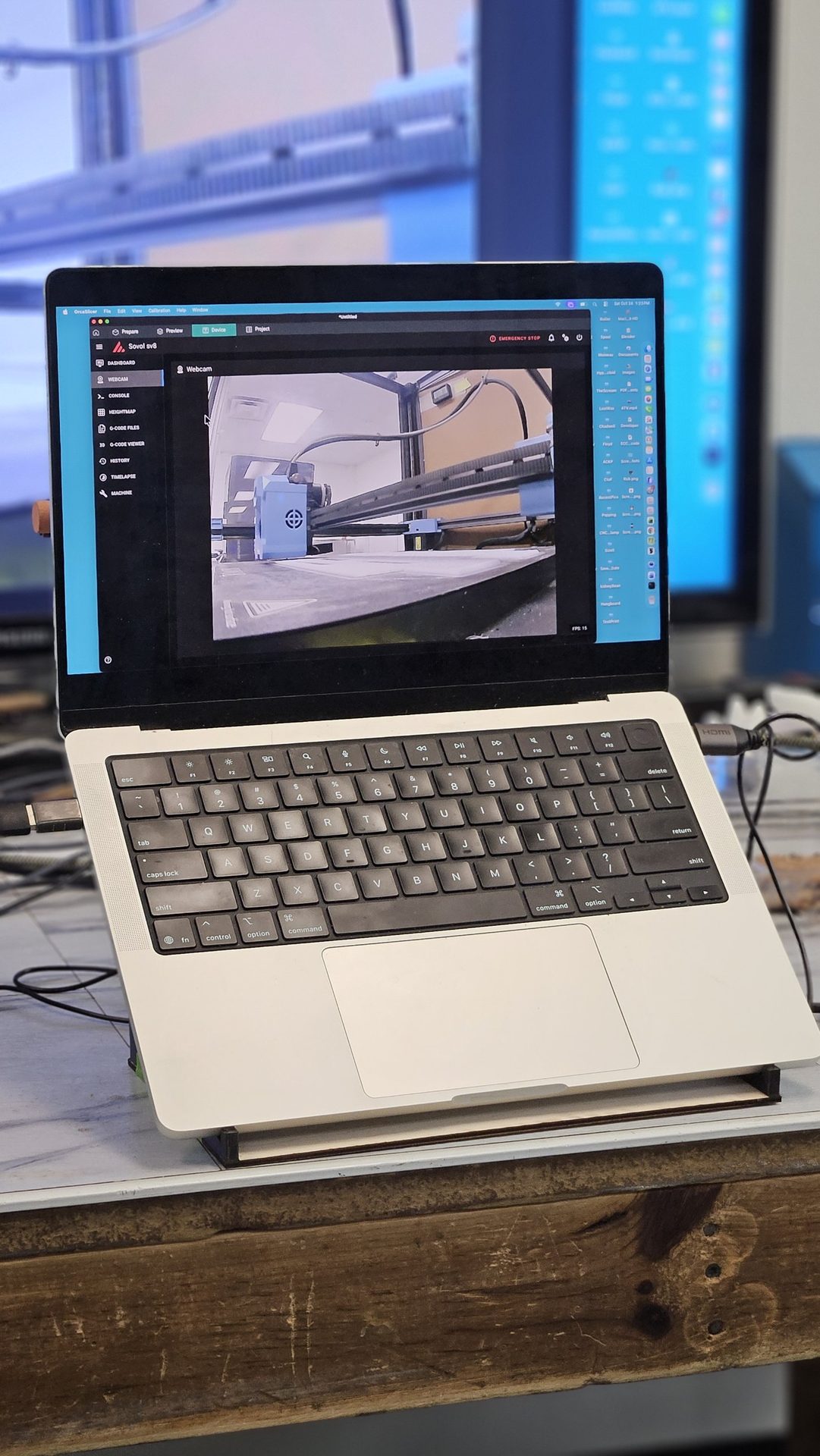 Laptop resting on DeskDrive Pro opened into an angled laptop stand on a workbench